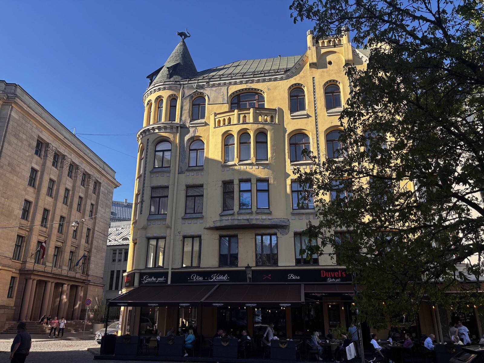 La Casa dei Gatti (Kaķu nams) su Meistaru iela nella Città Vecchia di Riga, con la sua facciata gialla in stile Art Nouveau e il gatto di bronzo sulla torretta d’angolo, Lettonia.