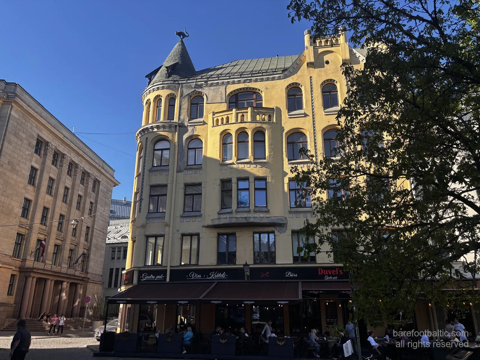 La Casa dei Gatti (Kaķu nams) su Meistaru iela nella Città Vecchia di Riga, con la sua facciata gialla in stile Art Nouveau e il gatto di bronzo sulla torretta d’angolo, Lettonia.