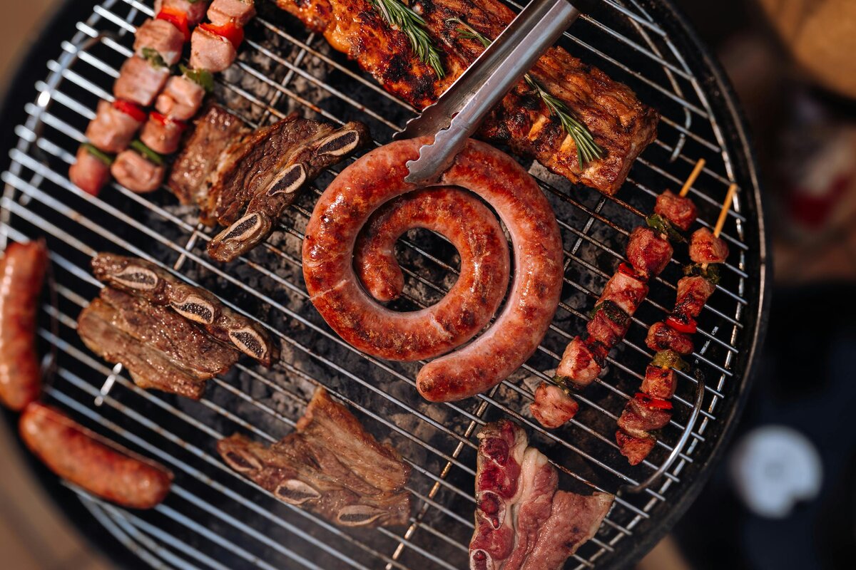 Salsiccia lettone arrotolata, costine di maiale, costine corte di manzo e spiedini su una griglia a carbone, il fondamento della cucina lettone.