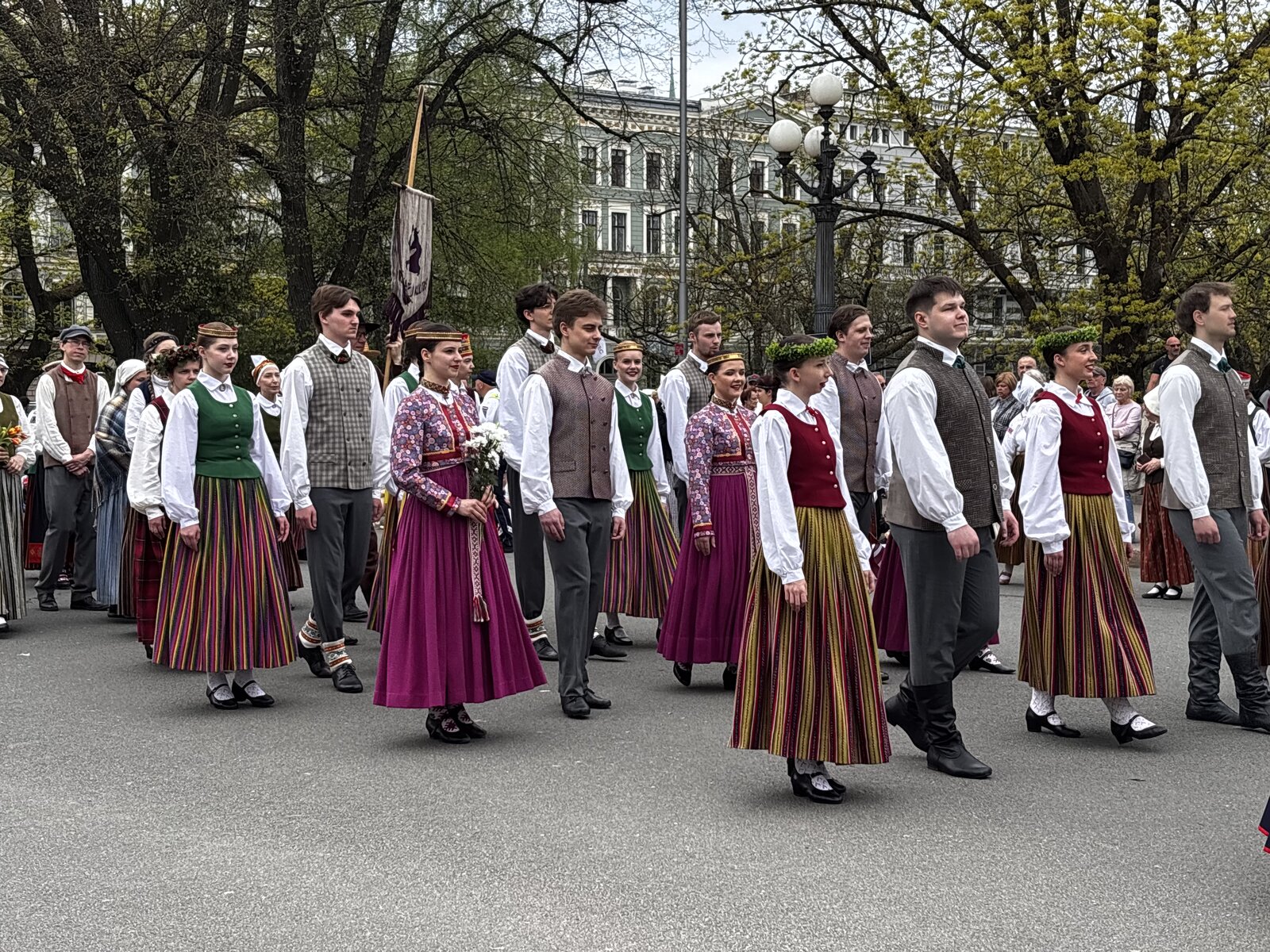 Guardia d'onore dell'Esercito lettone al Monumento della Libertà con una parete di fiori deposta contro la base, Riga, nel Giorno del Ripristino dell'Indipendenza