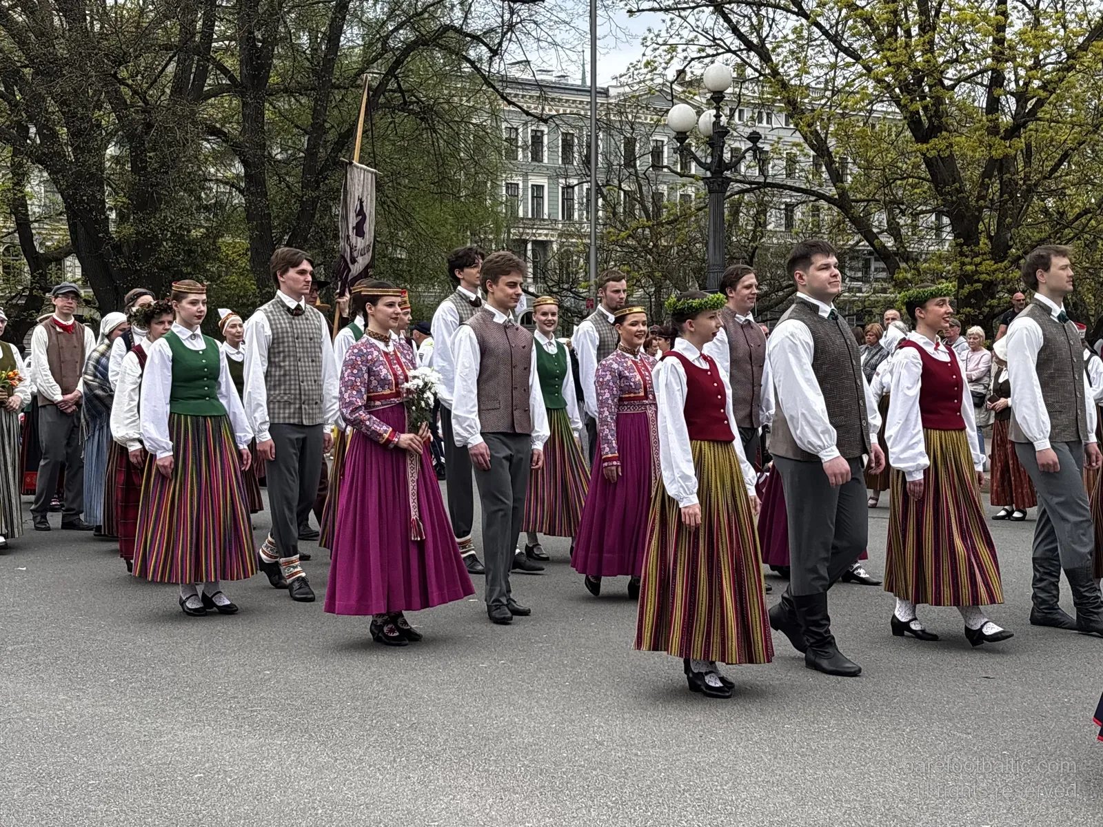 Guardia d'onore dell'Esercito lettone al Monumento della Libertà con una parete di fiori deposta contro la base, Riga, nel Giorno del Ripristino dell'Indipendenza