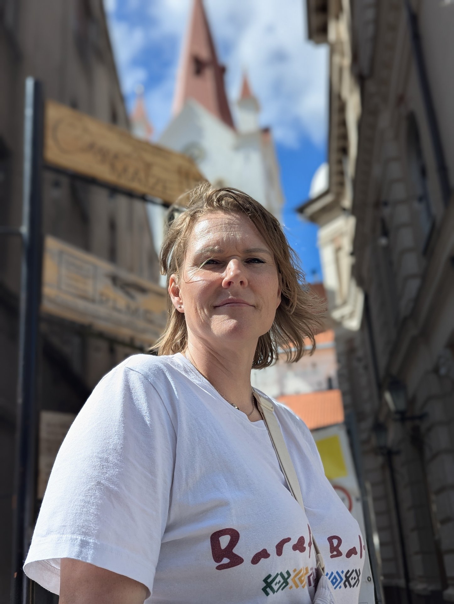 Daiga con la maglietta Barefoot Baltic, sullo sfondo il campanile del centro storico di Cēsis