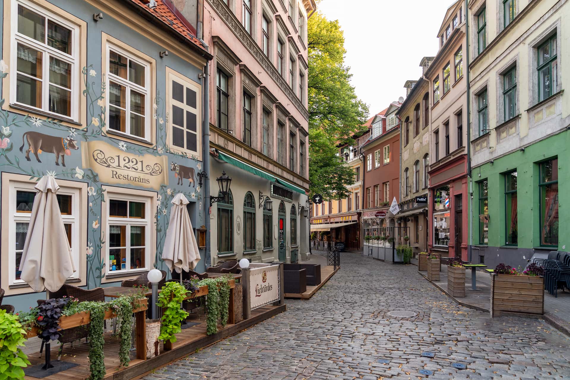 Stretta strada di ciottoli nella Città Vecchia di Riga con facciate anseatiche restaurate